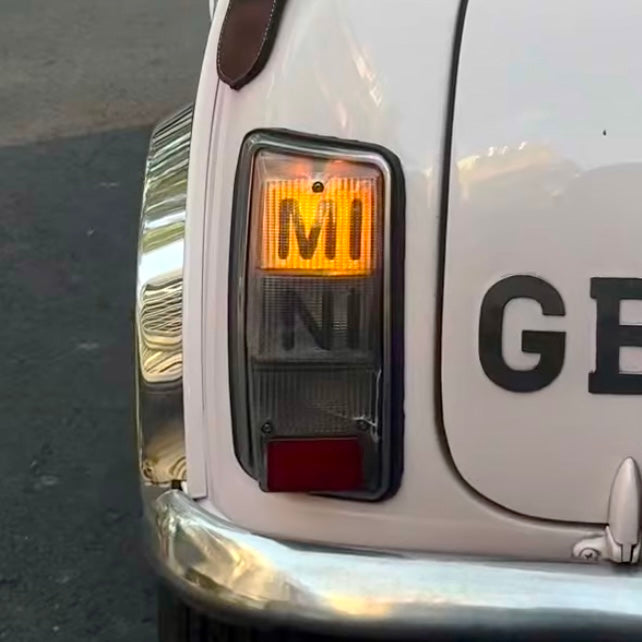 Kit adhésif MINI Édition Limitée installé dans le cabochon de feu arrière d'une Mini Austin MK2 à MK3 blanche, clignotant allumé

 Copier