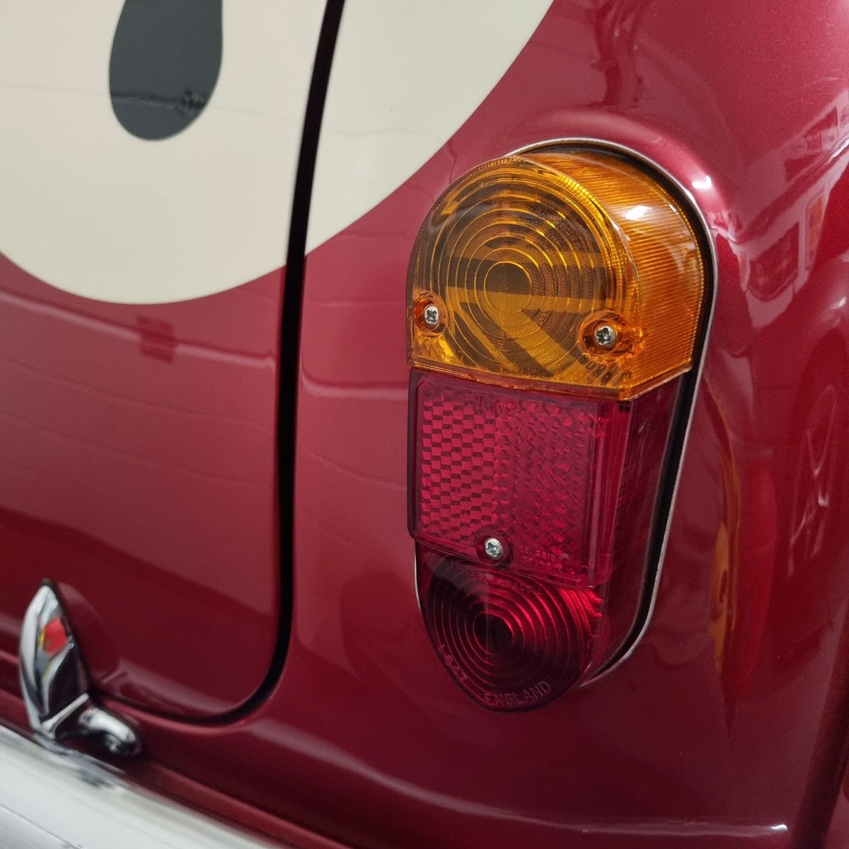 Gros plan sur le cabochon de feu arrière d'une Mini Austin rouge avec motif Union Jack MK1 installé à l'intérieur