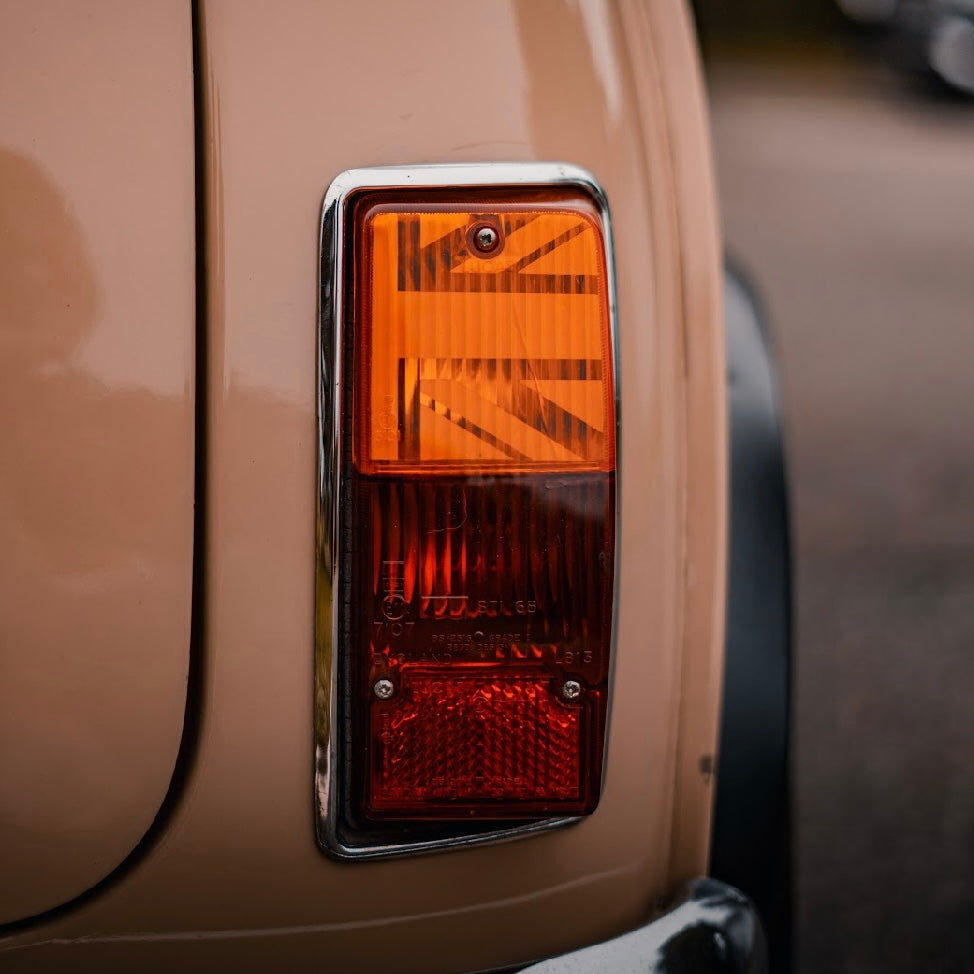 Feu arrière d'une Mini Austin beige avec kit adhésif Union Jack MK2-3 installé à l'intérieur du cabochon orange d'origine