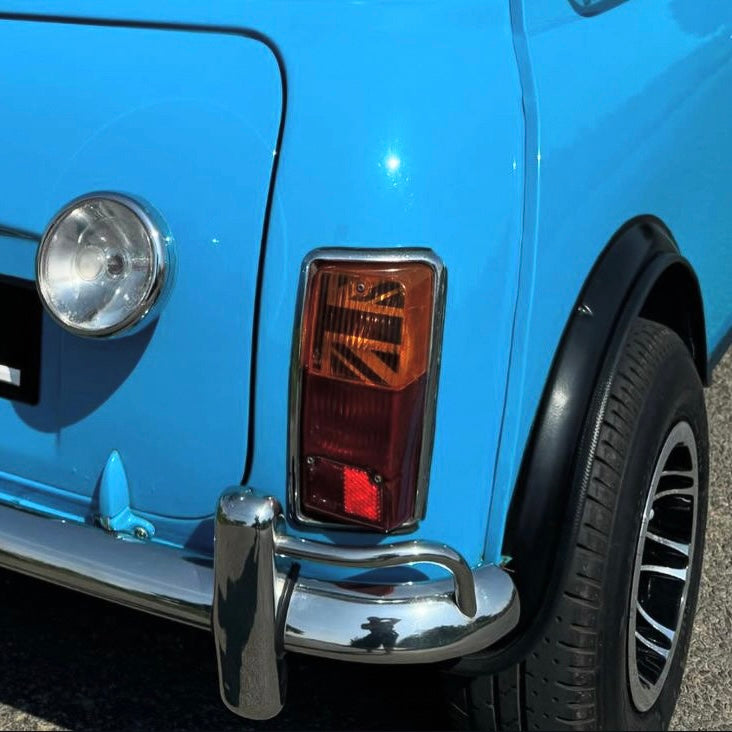 Vue arrière d'une Mini Austin bleu ciel avec kit adhésif Union Jack MK2-3 visible dans le cabochon de feu orange
