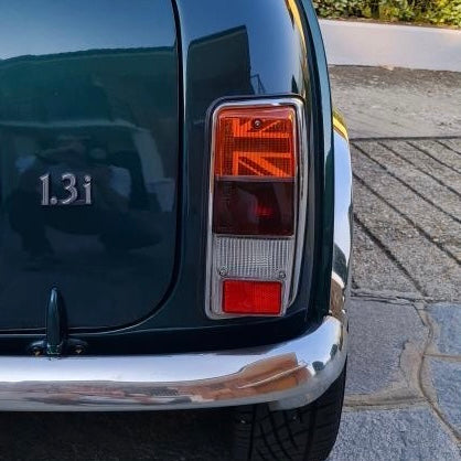Vue arrière d'une Mini Austin vert foncé avec motif Union Jack noir dans le cabochon orange du clignotant