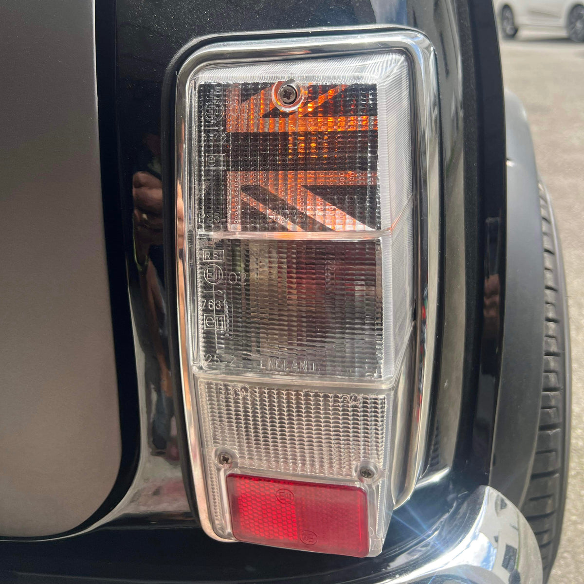 Mini Austin noire avec kit adhésif Union Jack installé à l'intérieur d'un cabochon de feu arrière transparent